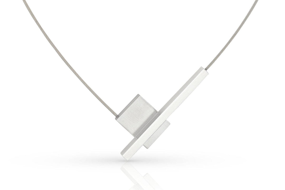 Ontdek de moderne Collier V-vorm met staafje C261 van CLIC Creations, met een uniek ontwerp met twee elkaar kruisende rechthoekige zilveren hangers aan een dunne draadketting. Handgemaakt in Nederland, voorzien van een eenvoudige magnetische sluiting, elegant gepresenteerd tegen een witte achtergrond.