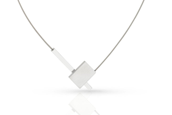 De Collier V-vorm met staafje C261 van CLIC Creations is een minimalistische zilveren ketting met een geometrische hanger, bestaande uit een overlappende rechthoekige vorm en een dun staafje, bevestigd aan een fijne ketting met een magneetsluiting, tegen een witte achtergrond.