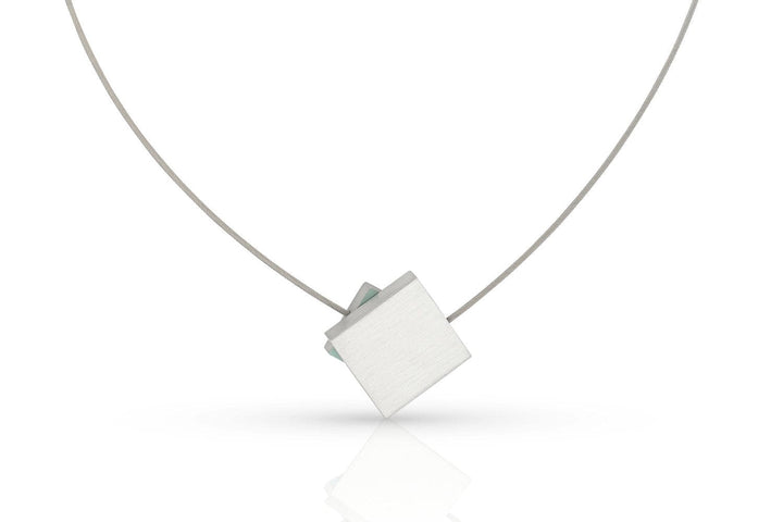 De CLIC Creations Collier Vierkant met gekleurd vierkant C263B heeft een minimalistisch design met een dun zilverkleurig draadje en een geometrische, vierkante hanger die schuin hangt, afgewerkt met een strakke magneetsluiting voor eenvoudig dragen.
