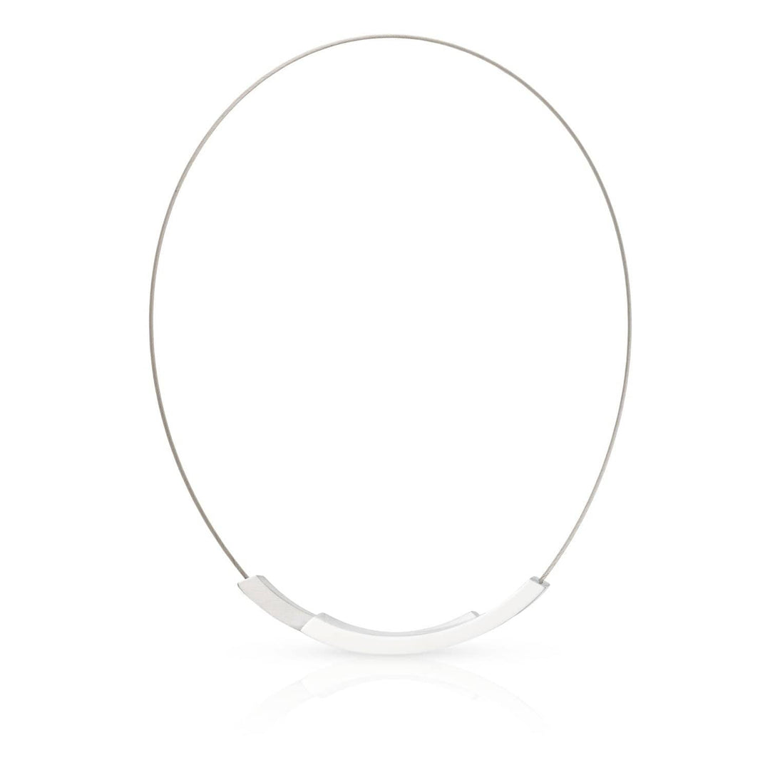 De CLIC Creations Collier Bogen C74 is een minimalistische zilveren ketting met een dunne draad en een gepolijst gebogen metalen middenstuk. Deze halsketting met magneetsluiting wordt weergegeven op een effen witte achtergrond en toont eenvoud en elegantie, en belichaamt de principes van Uniek design.