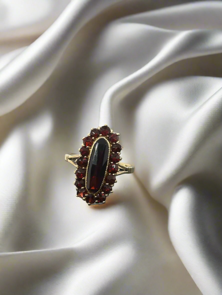Anillo vintage de oro de 14k con granate ovalado y detalles en granate.