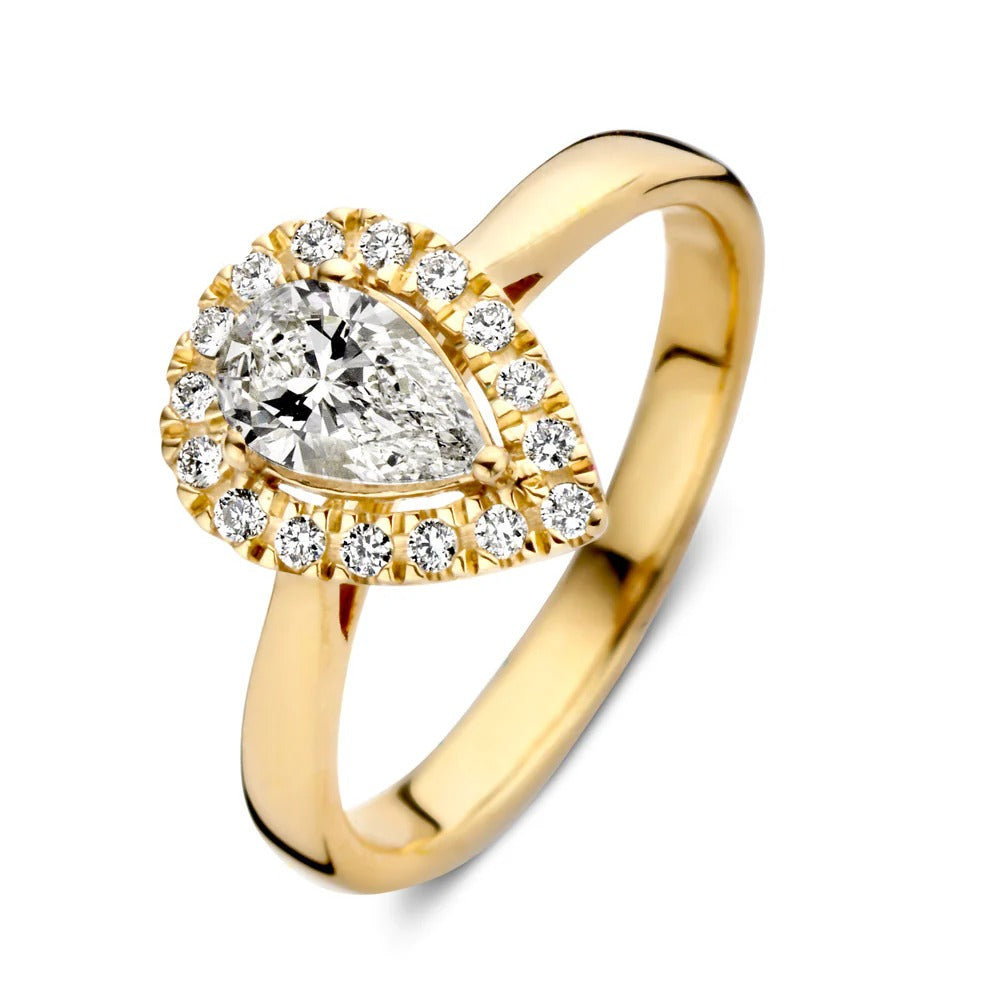 Anillo de oro amarillo con diamante en forma de pera y circonitas alrededor.