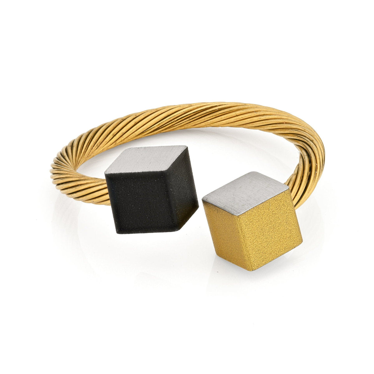 Anillo dorado con cubos negro y dorado, diseño de alambre trenzado.