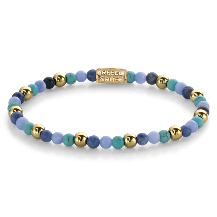 De Rebel & Rose Winter Blues - 18 kt geelgouden geïoniseerde 4mm Kralen Armband Dames heeft afwisselend turquoise en blauwe agaat kralen met een gouden rechthoekige bedel, gerangschikt in een cirkel op een witte achtergrond.