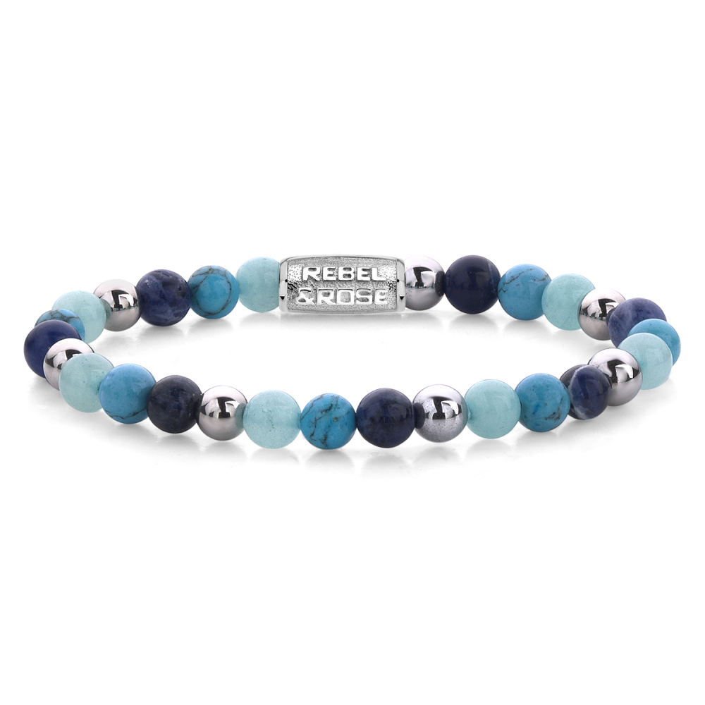 De Blue Summer Vibes - 6mm Kralen Armband Dames van Rebel & Rose heeft afwisselend blauwe, turquoise en zilveren kralen met een rechthoekige zilveren bedel waarin de merknaam is gegraveerd.