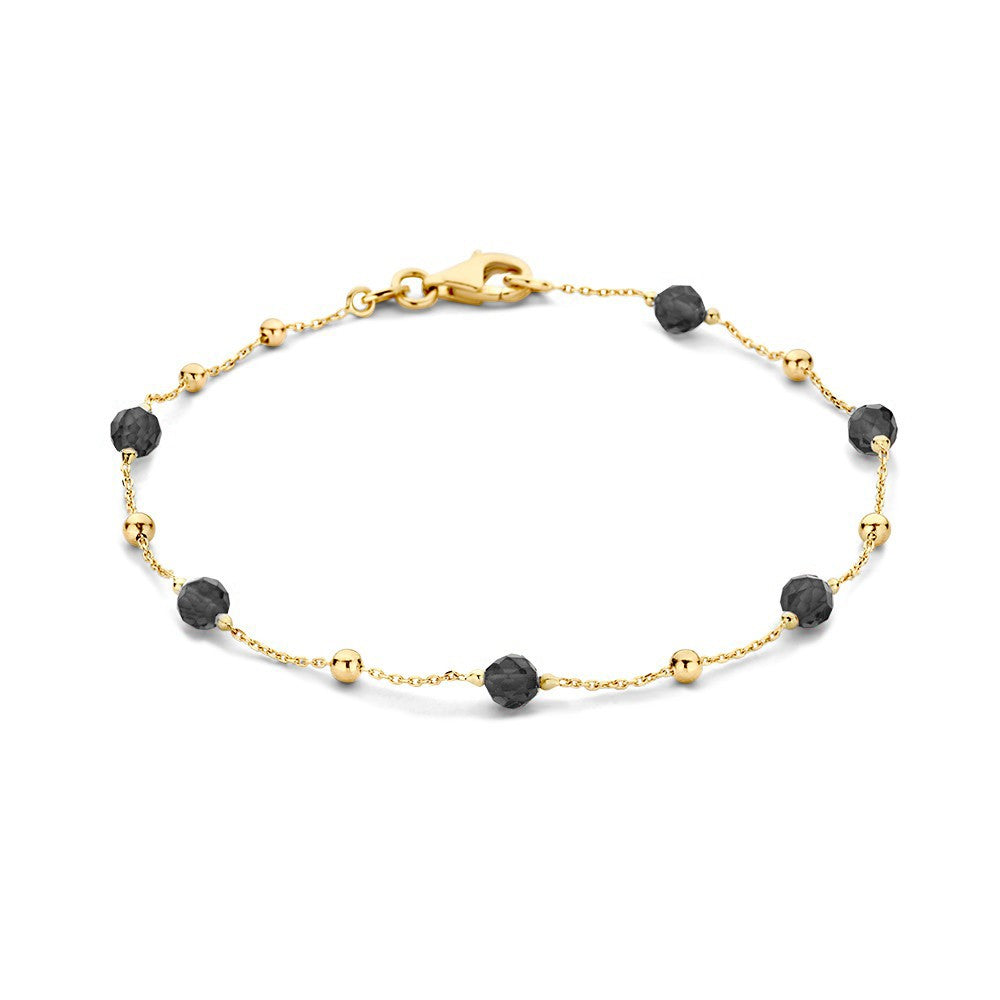 Pulsera de oro amarillo con zirconias y cuentas negras.