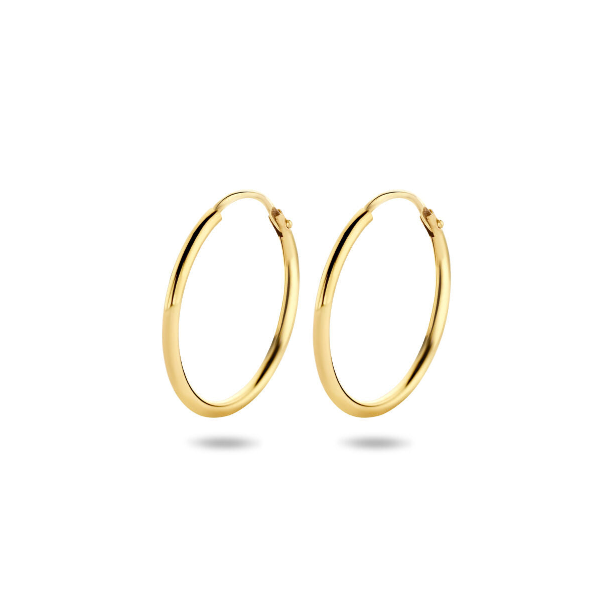 Een paar Van der Kooij Collectie oorringen 1,5 mm ronde buis in 14K geelgoud met scharniersluiting getoond op een effen witte achtergrond, waardoor er zachte schaduwen onder vallen.