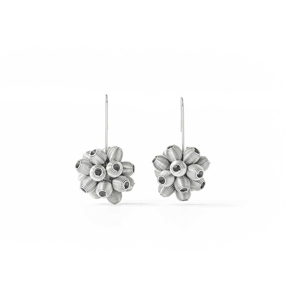Pendientes largos de plata con forma de flor y detalles en relieve.