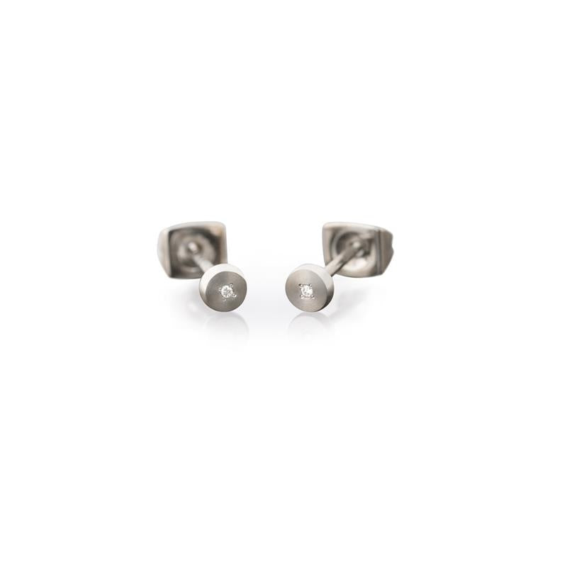 Pendientes de titanio con un diseño minimalista, forma redonda y un pequeño brillante en el centro.