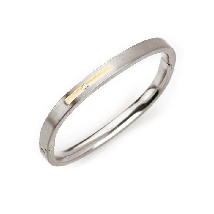 De Boccia Titanium Armb. Sp. Bicolor 0304-01 van Boccia heeft een strak zilverkleurig en goudkleurig ontwerp met een klein rechthoekig gouden accent en een centrale ronde diamant op het gouden detail.