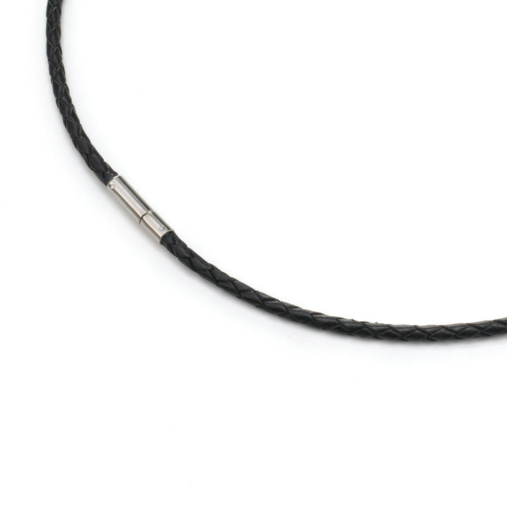 Een close-up van de Boccia Titanium Lengte Collier leer 0835-01, een zwart gevlochten leren collier met een klein zilveren slotje van Boccia, afgebeeld op een witte achtergrond. Dit sieraad benadrukt elegant vakmanschap en een tijdloze stijl.
