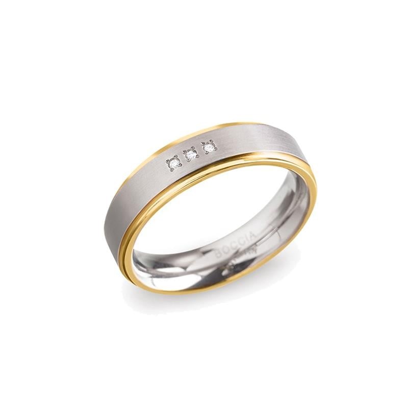 Anillo bicolor de titanio con detalles en oro y tres diamantes pequeños.