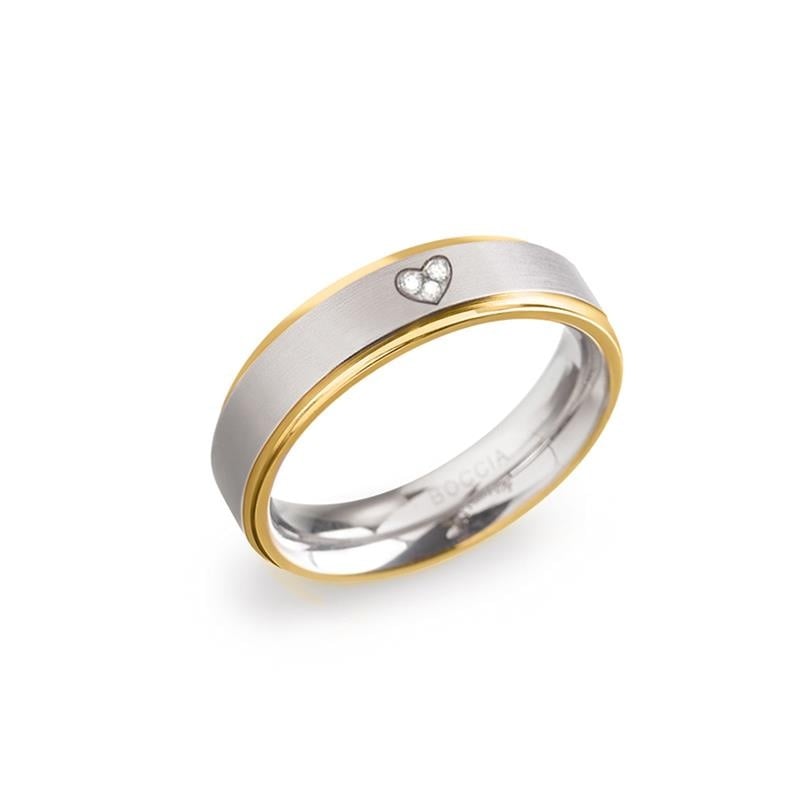 Anillo bicolor de titanio con un corazón y una pequeña piedra brillante.