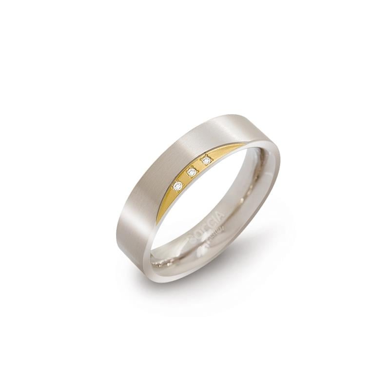 Anillo bicolor de titanio con tres diamantes en la parte central.