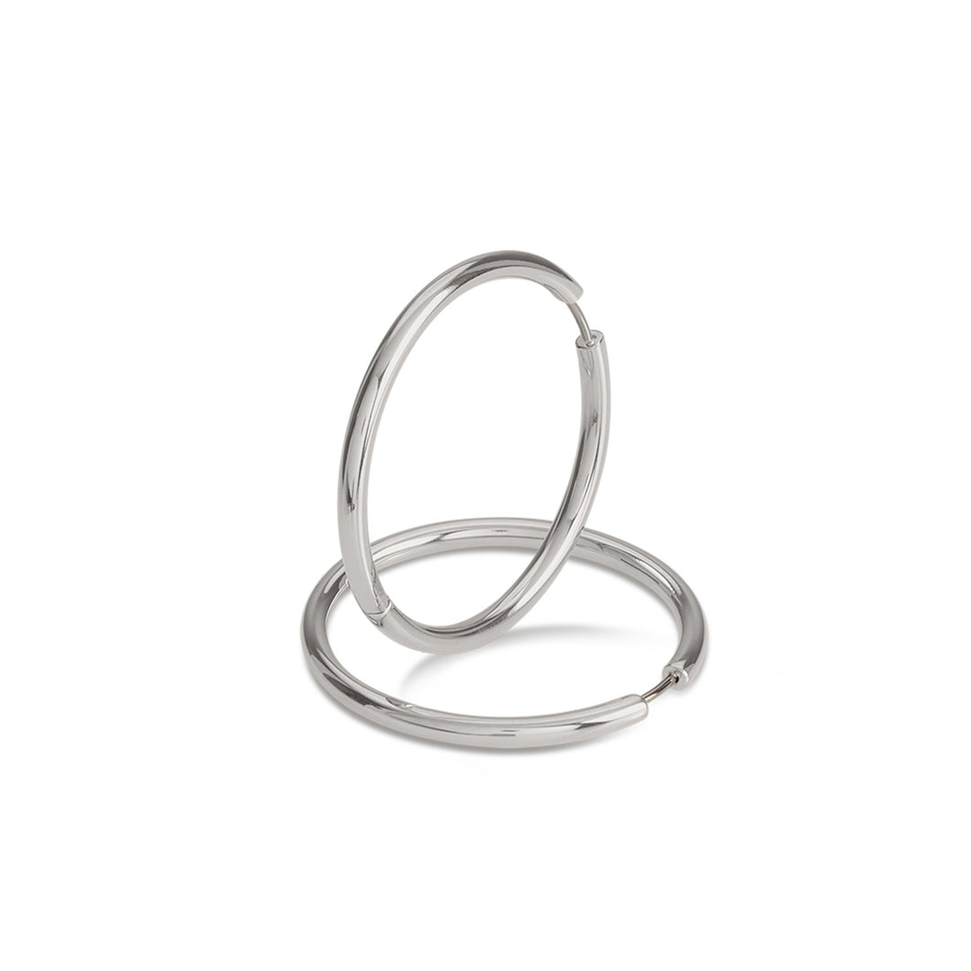 Een paar elegante Boccia Titanium Oorringen 05070-01 met een gladde, zilveren afwerking wordt getoond tegen een witte achtergrond – één rechtopstaand, één liggend. Deze tijdloze titanium oorbellen van Boccia vormen een perfecte aanvulling op elke sieradencollectie.