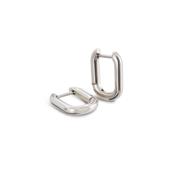 De Boccia Titanium Oorringen 05060-01 zijn glanzende, zilverkleurige oorbellen met een dikke, afgeronde ovale vorm en zichtbare scharniersluitingen. Eén oorbel staat rechtop, de andere ligt plat. Merk: Boccia.