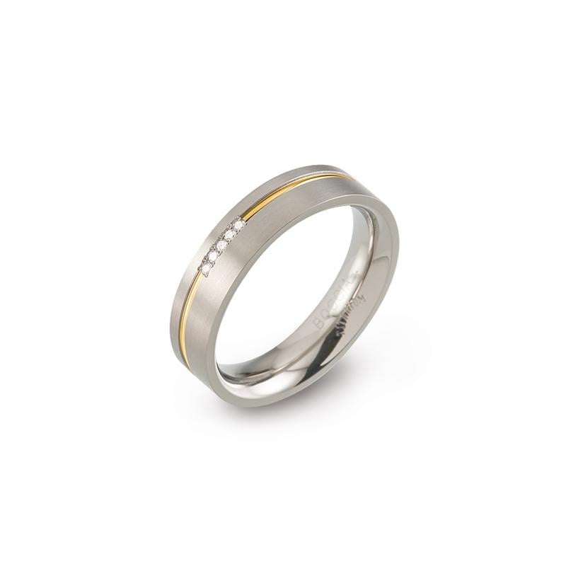 Anillo de titanio bicolor con un acabado pulido y tres pequeñas piedras brillantes.