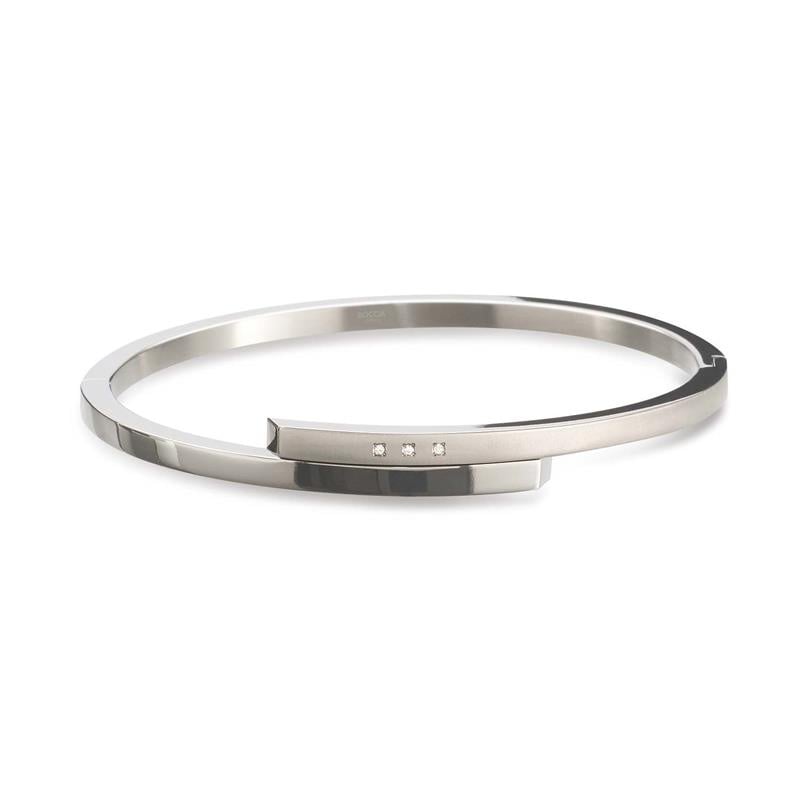 Pulsera de titanio con diseño minimalista y tres pequeñas piedras brillantes.