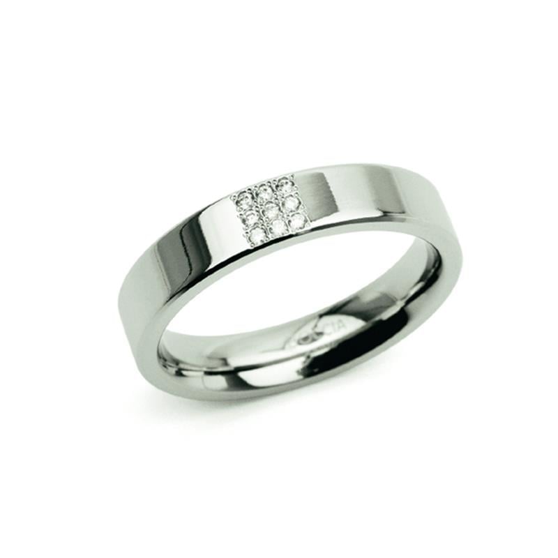 Anillo de titanio plateado con diamantes en el centro y acabado pulido.