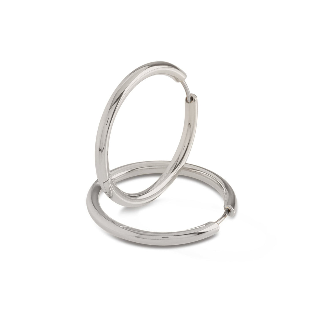 Er worden twee glanzende Boccia Titanium Oorringen 05073-01 getoond, waarbij de ene oorbel rechtop in de andere staat op een effen witte achtergrond, waardoor het elegante klapsluiting-ontwerp wordt benadrukt.