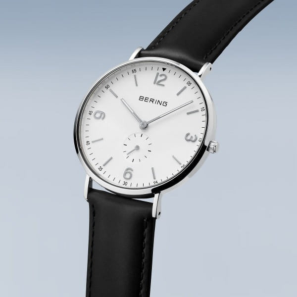 De Bering 14040-404 is een minimalistisch herenhorloge met een witte wijzerplaat, zilveren kast, zwarte markeringen en zwarte leren band. Dit stijlvolle kwartsuurwerk heeft een kleine secondewijzer boven de 6-uurspositie.