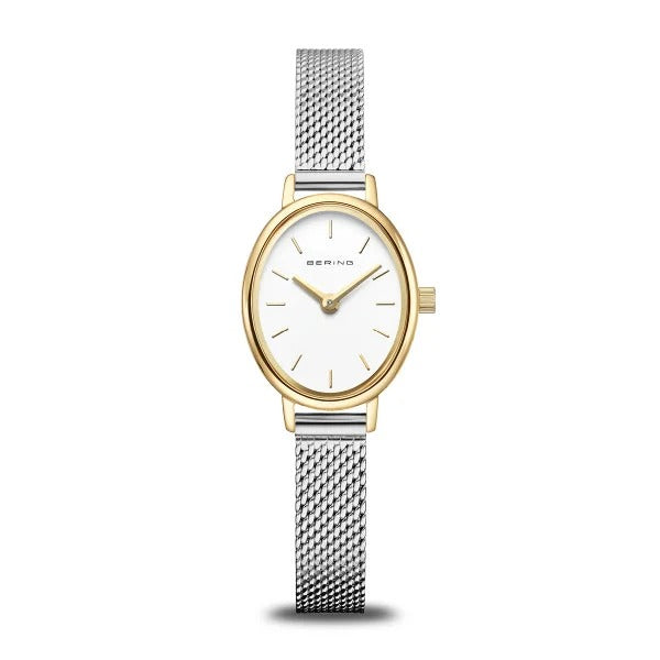 Reloj ovalado con esfera blanca, caja dorada y correa de malla plateada.