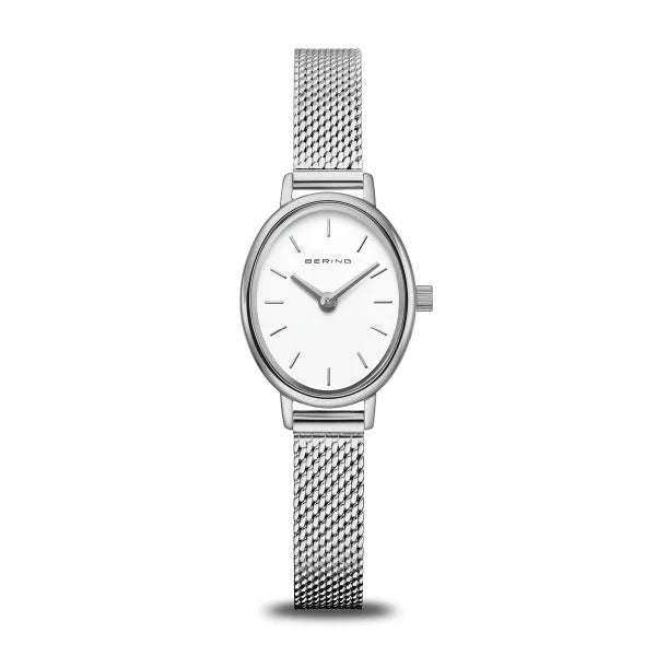 De Bering 11020-004 is een minimalistische zilverkleurige dameshorloge met een ovale wijzerplaat, een metalen band van mesh, een effen witte wijzerplaat zonder cijfers en twee slanke wijzers voor uren en minuten.
