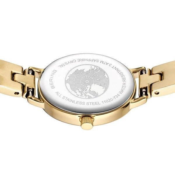 De afbeelding toont de achterkant van een Bering 11020-734 goudkleurig dameshorloge met een roestvrijstalen kast gegraveerd met een wereldkaart en de tekst: BERING, SAPPHIRE CRYSTAL, WATER RESISTANT en quartz uurwerk.