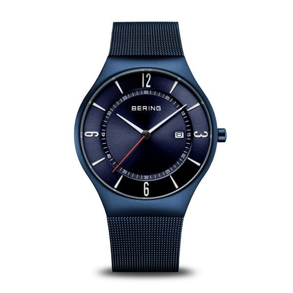 Reloj de esfera azul con correa de malla, números en blanco y indicador de fecha.