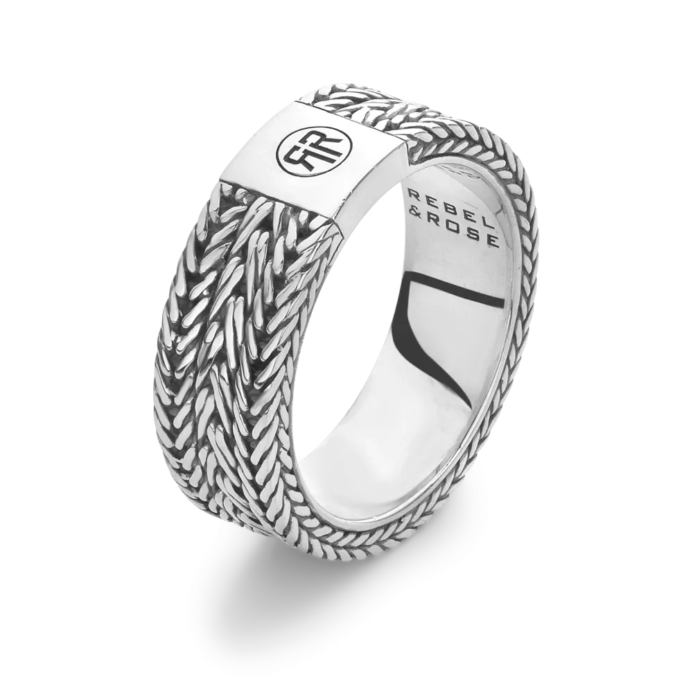 Anillo de plata con diseño trenzado y detalle en la parte superior.