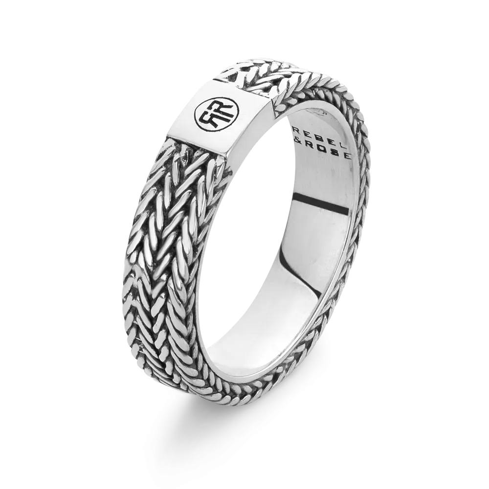 Anillo de plata con diseño trenzado y detalle en el centro.