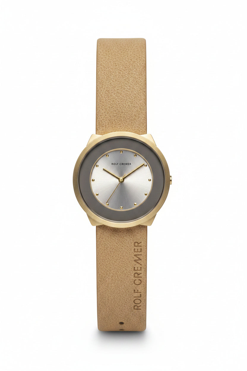 Reloj con caja dorada, esfera plateada y correa de cuero beige.