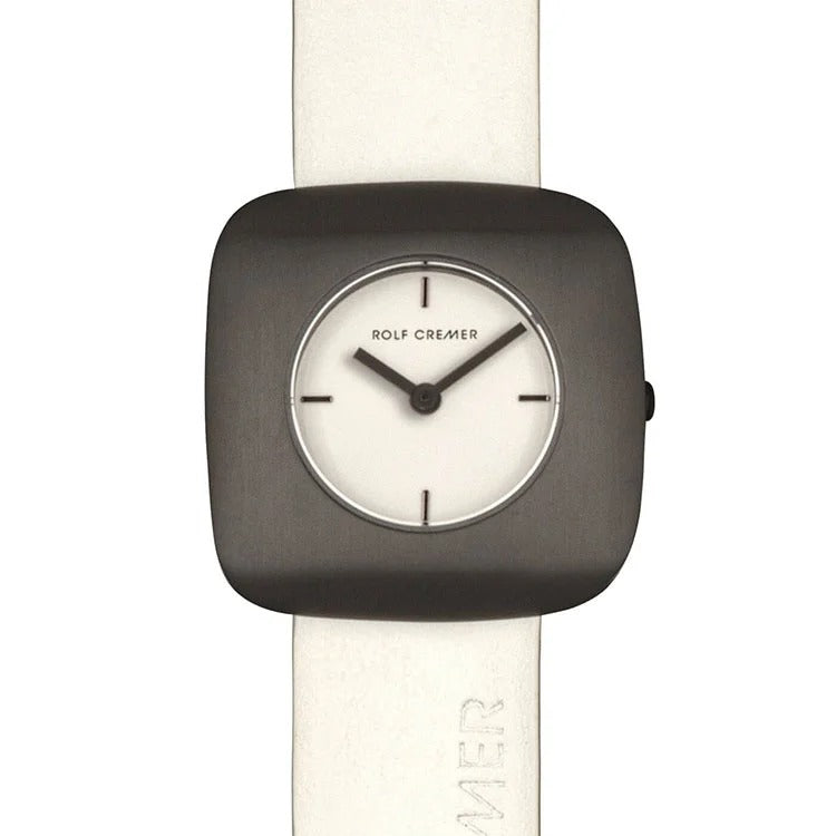 Reloj cuadrado de Rolf Cremer con esfera blanca y correa de cuero clara.