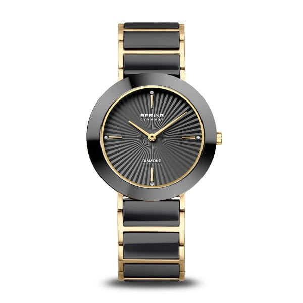 Reloj de esfera negra con detalles dorados y correa de eslabones en negro y dorado.