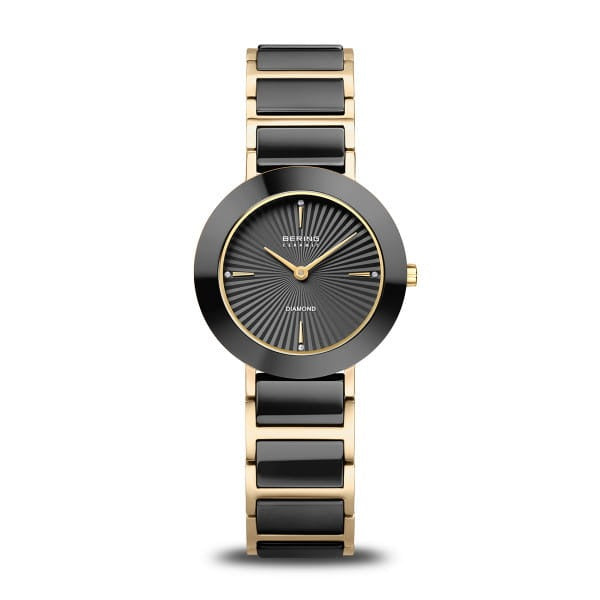 Reloj de mujer con esfera negra, correa de acero dorado y detalles en negro.