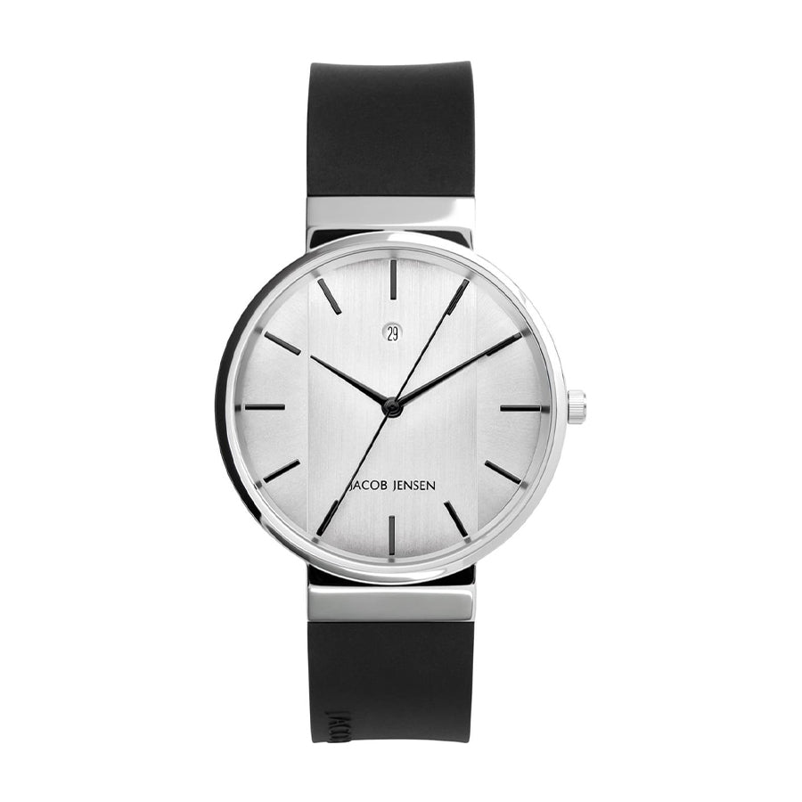 Reloj con esfera plateada, correa de silicona negra y detalles minimalistas en la caja.