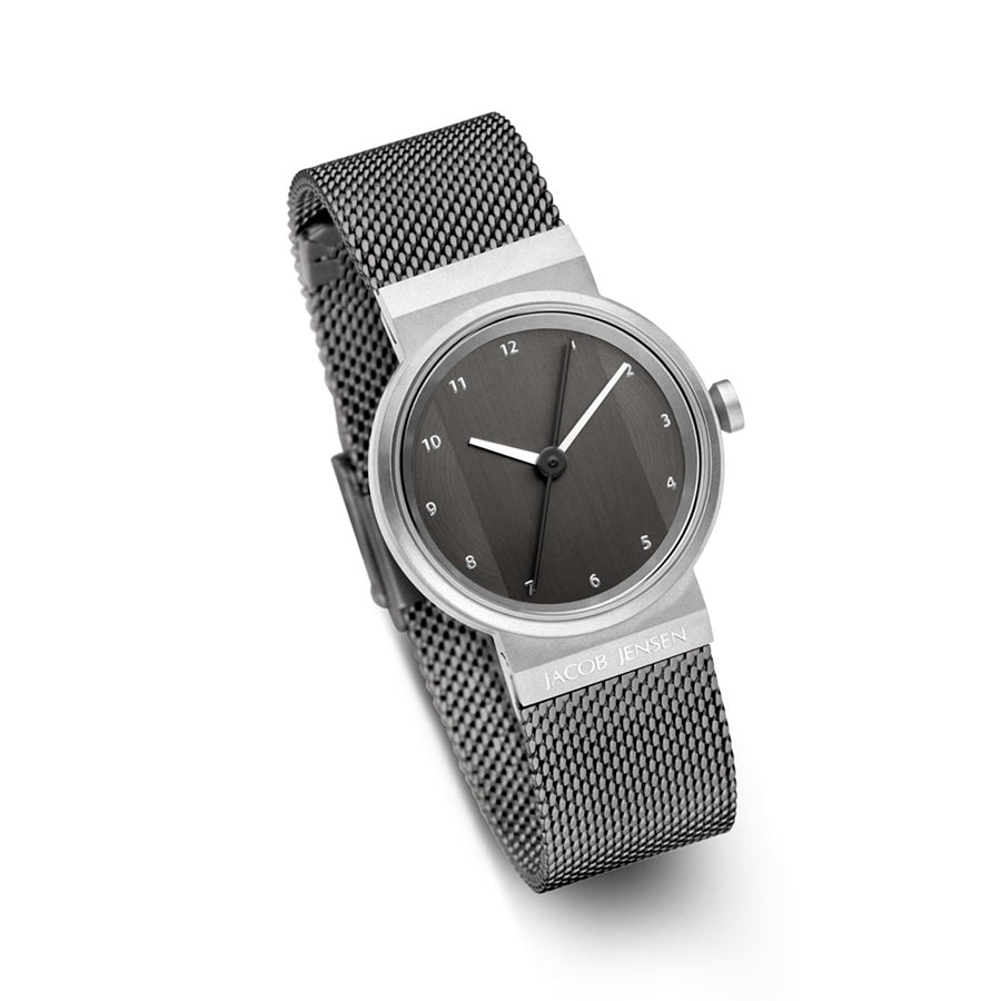 Reloj con esfera gris y correa de malla metálica plateada.