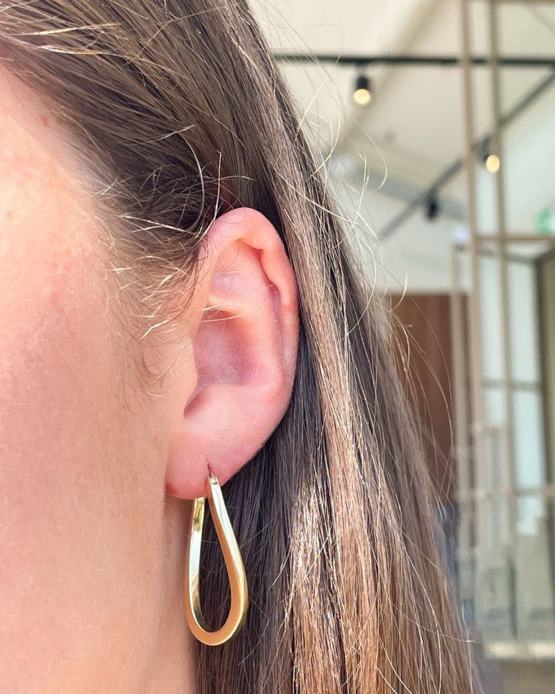 Aros de oro amarillo con giro juguetón – 14 quilates de oro