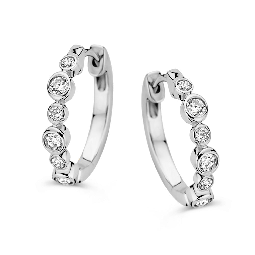 Aros de oro blanco con diamantes, diseño circular y detalles brillantes.