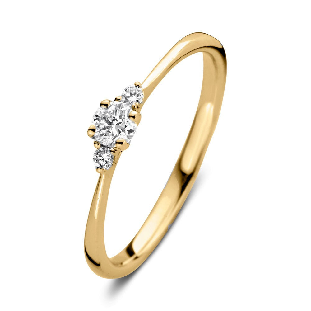 Anillo de oro amarillo con tres diamantes brillantes en el centro.