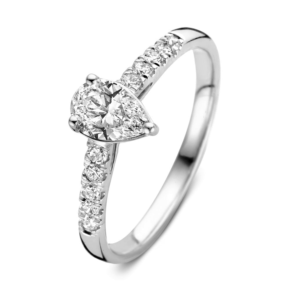 Anillo de oro blanco con diamante en forma de pera y piedras brillantes a los lados.