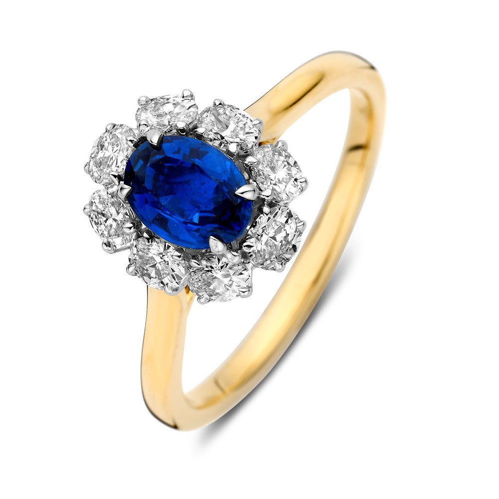 Anillo bicolor con un zafiro ovalado en el centro y diamantes brillantes alrededor.