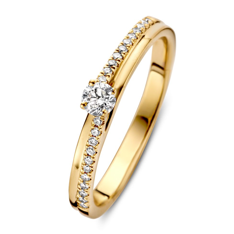 Anillo de dama en oro amarillo con una piedra central de brillante y bandas de diamantes finos de 0.21 crt.