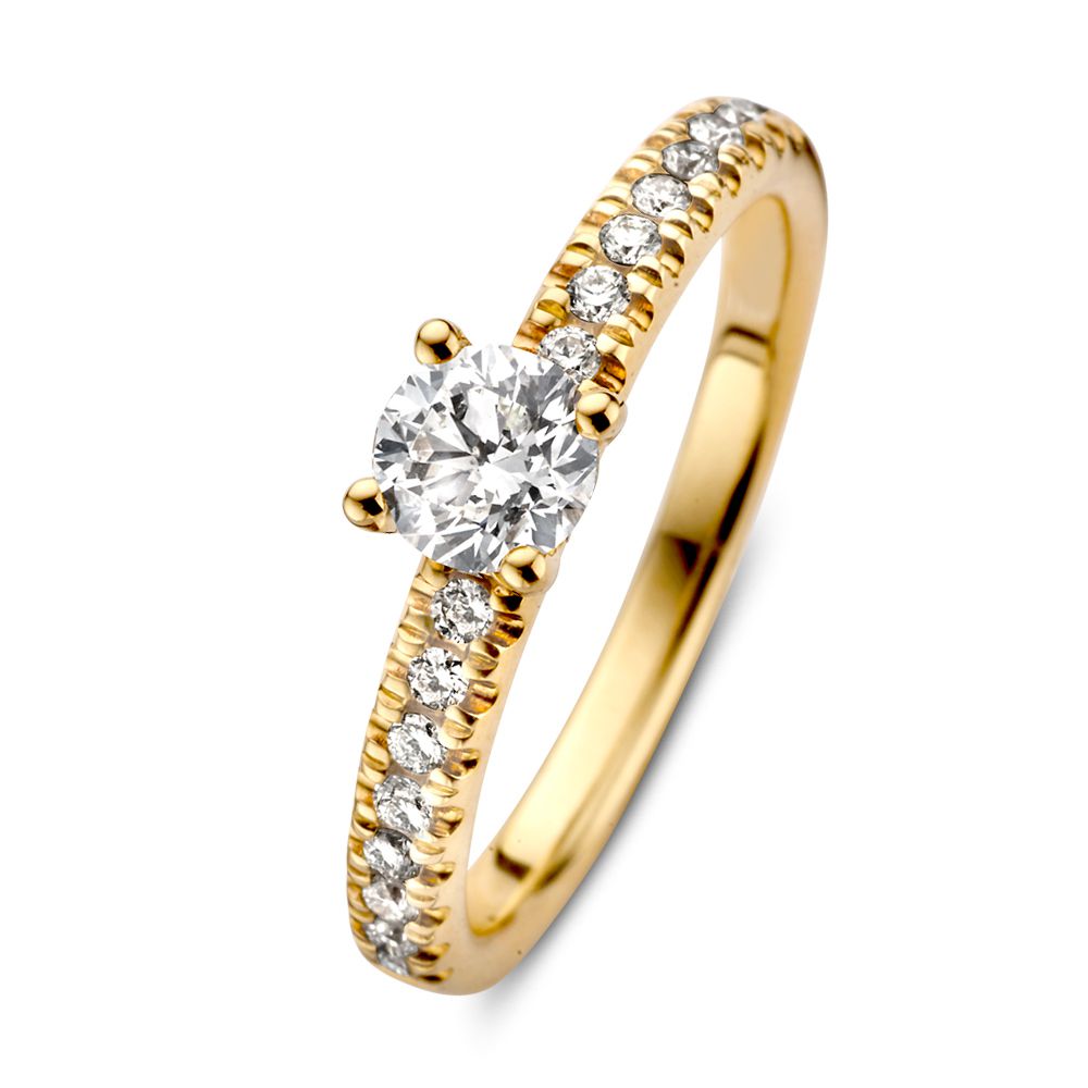 Anillo solitario de oro amarillo de 14 quilates con diamante brillante central y piedras laterales.