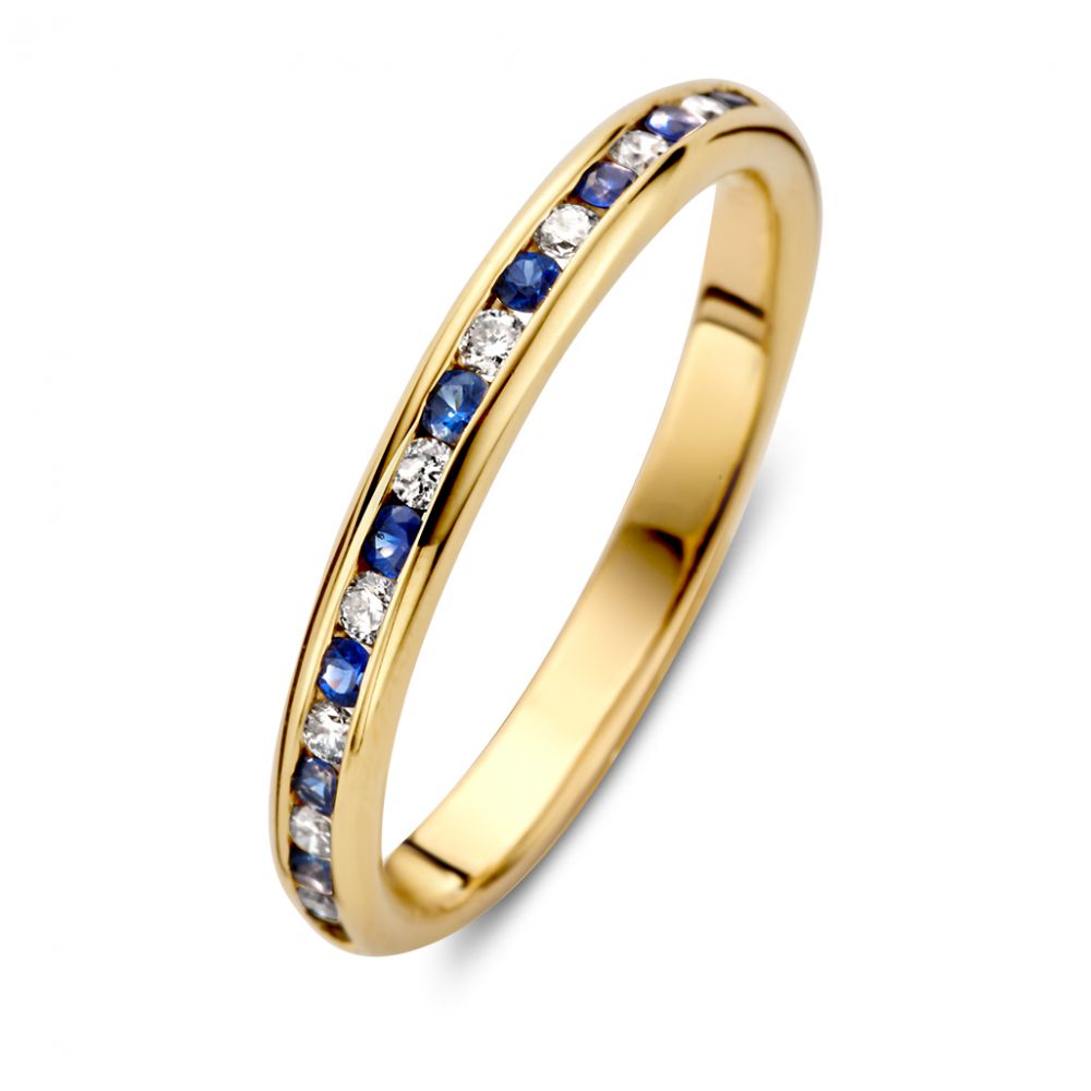 Anillo de oro amarillo refinado con diamantes y zafiros azules en engaste de riel.