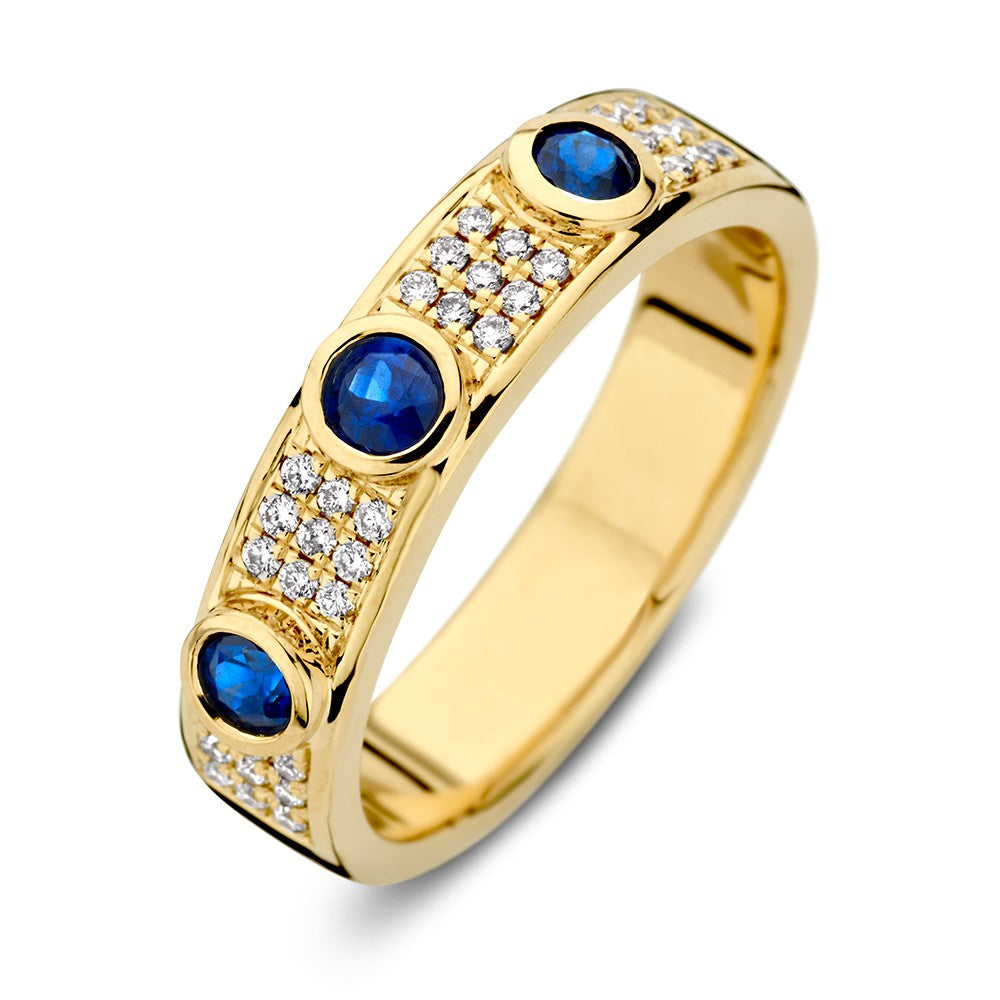 Anillo de oro amarillo de 14 quilates con diamantes y tres zafiros azules, con un diseño elegante.