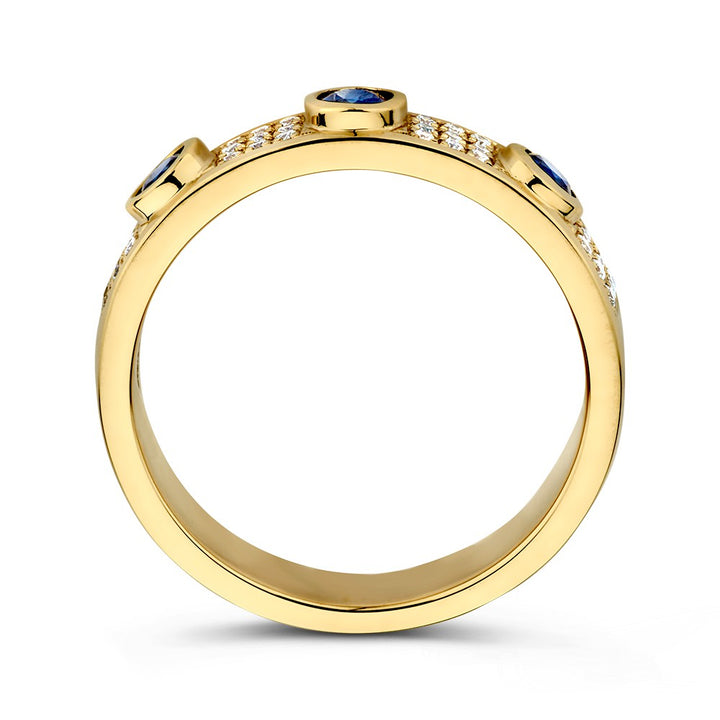 De Excellent Jewelry Geelgouden Ring met Diamant en 3 Blauwe Saffieren (14 karaat, 0.38 crt saffier, 0.17 crt diamant) is afgebeeld vanaf de zijkant met drie ronde saffieren bovenop en diamant accenten langs de band tegen een witte achtergrond.