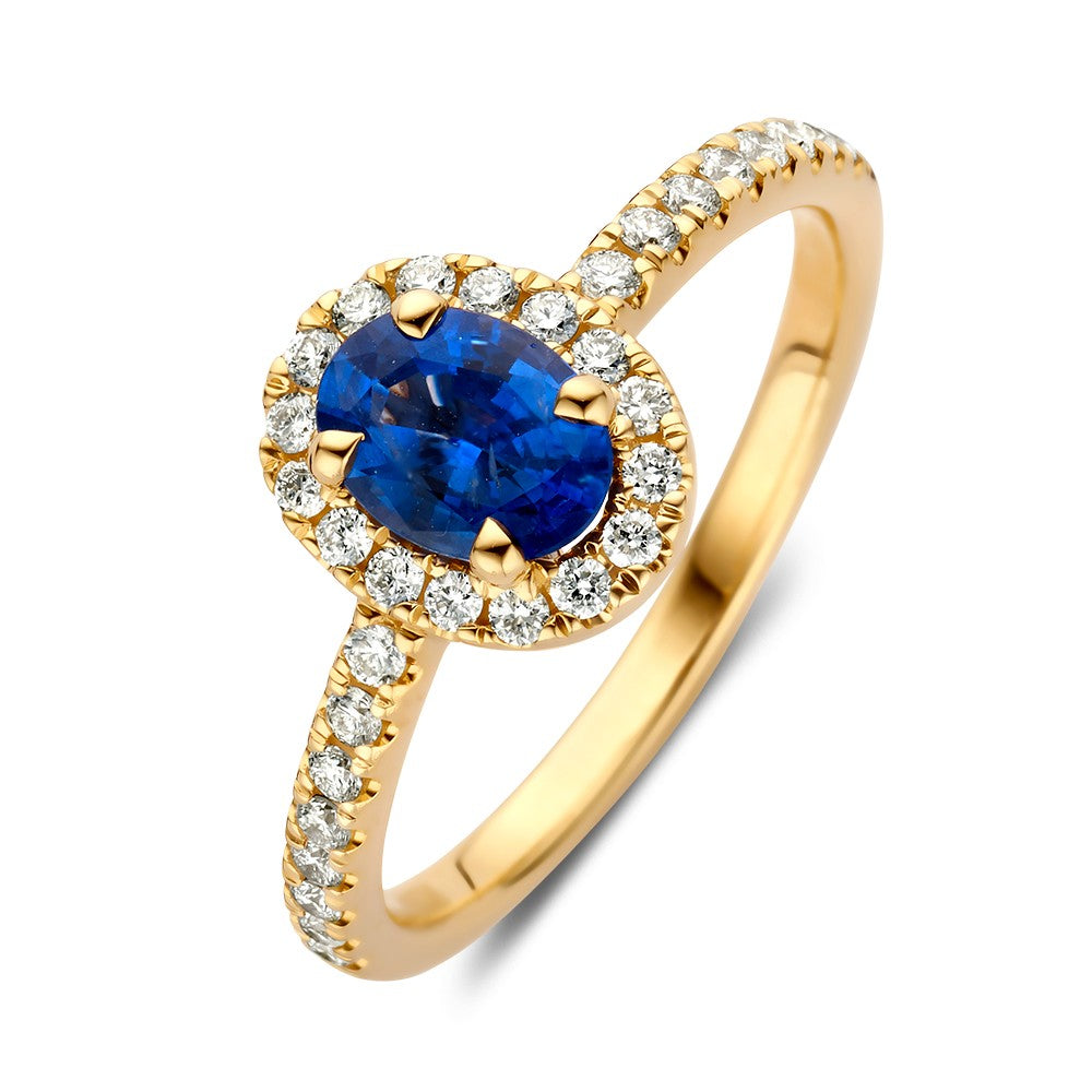 Anillo de oro amarillo con zafiro ovalado y diamantes brillantes alrededor.