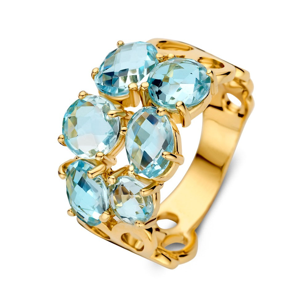 Anillo de oro amarillo con topacios azules y engaste orgánico, de diseño ancho para damas.
