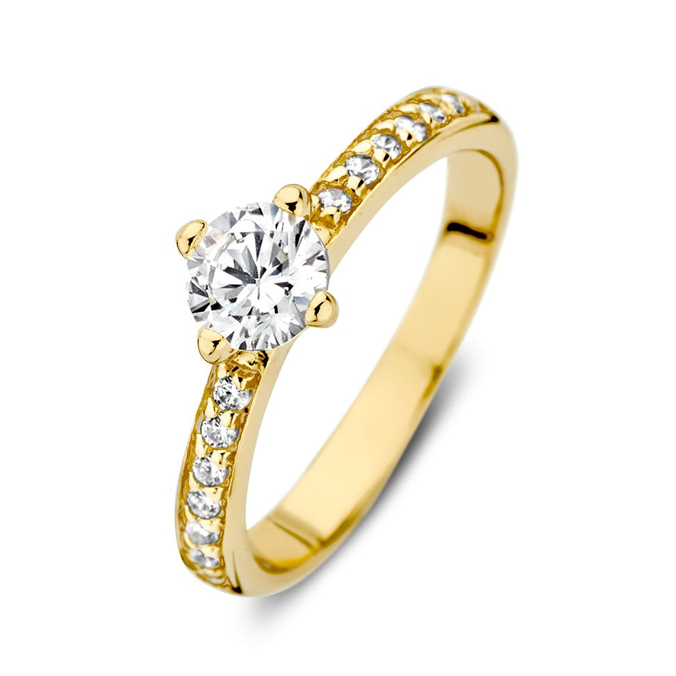 Anillo de oro amarillo de 14 quilates con un zircón central y piedras brillantes en el aro.